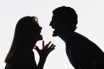 Silhouette of couple shouting at each other