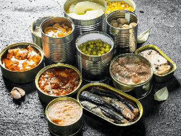 12 opened unlabeled tin cans containing various foods